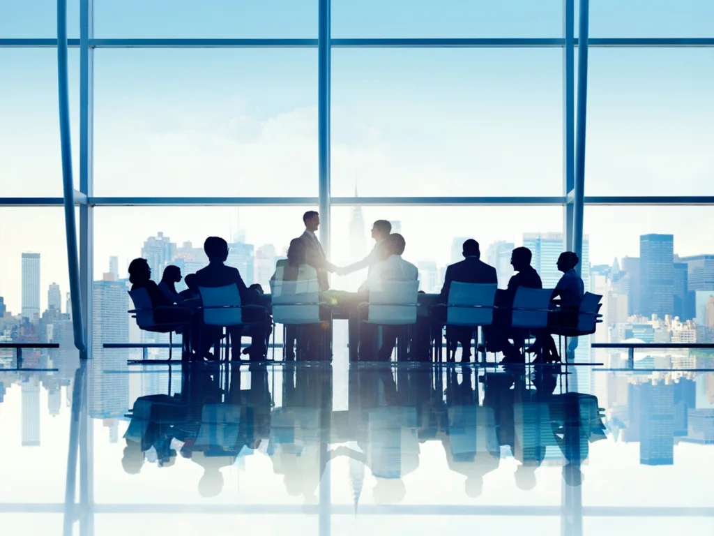 Shaking hands in boardroom.