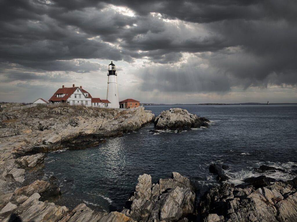 Cloudy sky over rippling sea and old lighthouse