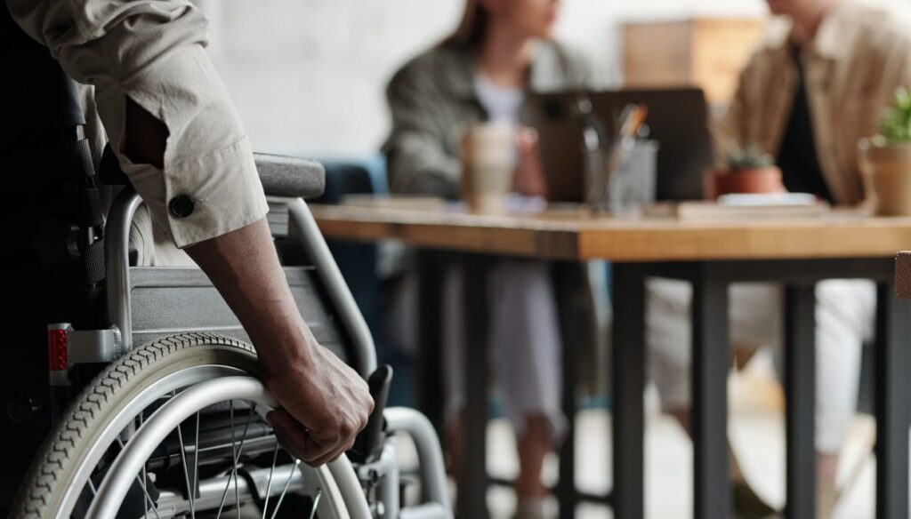 Young disabled person with hands on wheel of wheelchair